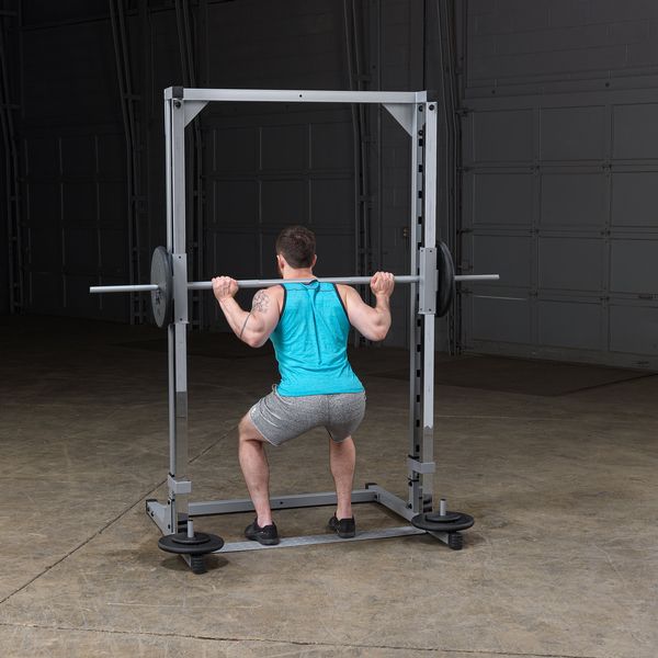 PowerLine Smith Machine con usuario haciendo sentadilla con barra