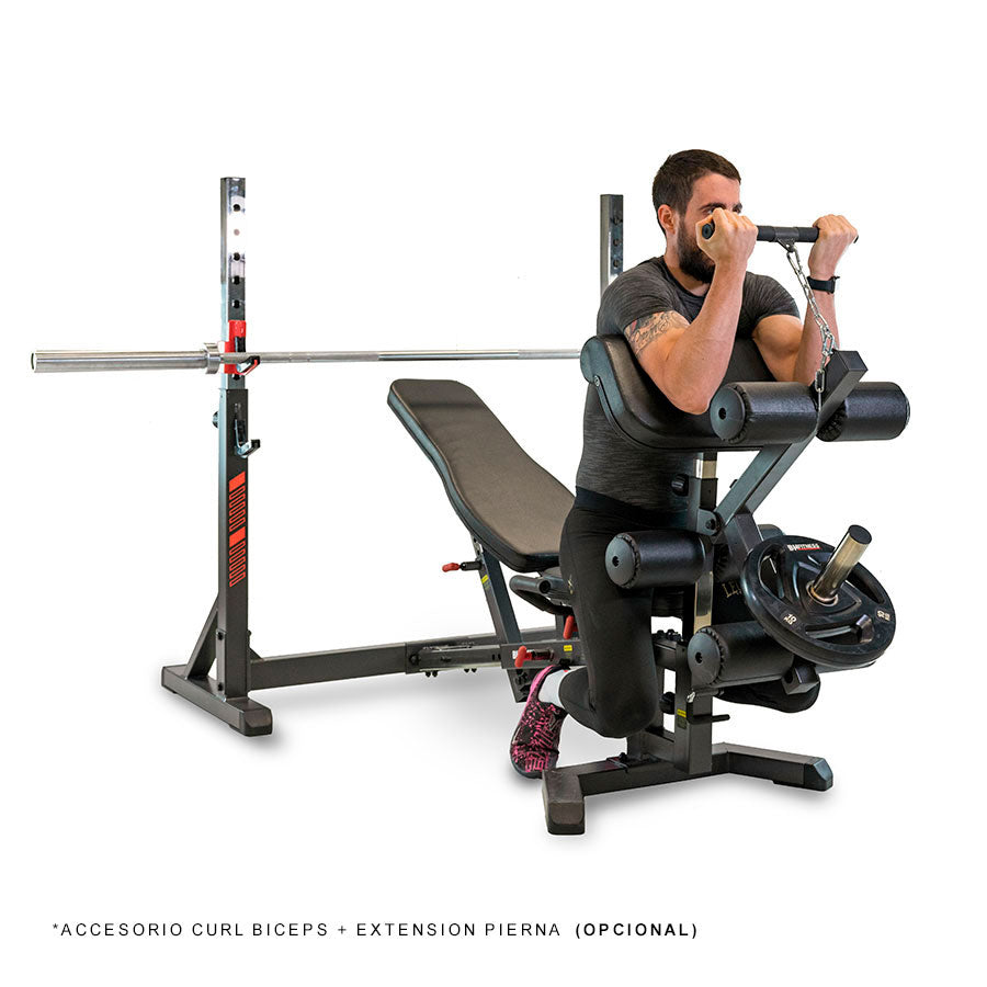 Hombre utilizando el Banco Olympic Rack G510 BH Fitness con el accesorio de curl biceps y extensión de pierna