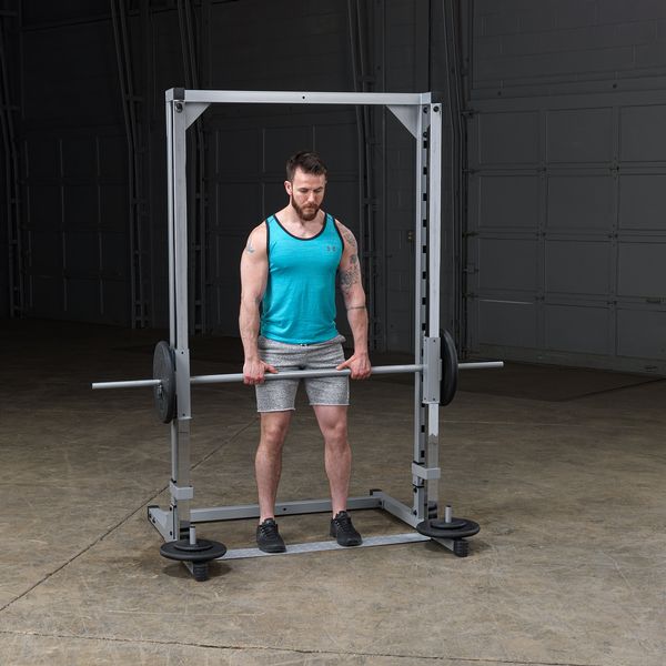 PowerLine Smith Machine con usuario de pie haciendo levantamiento de pesa
